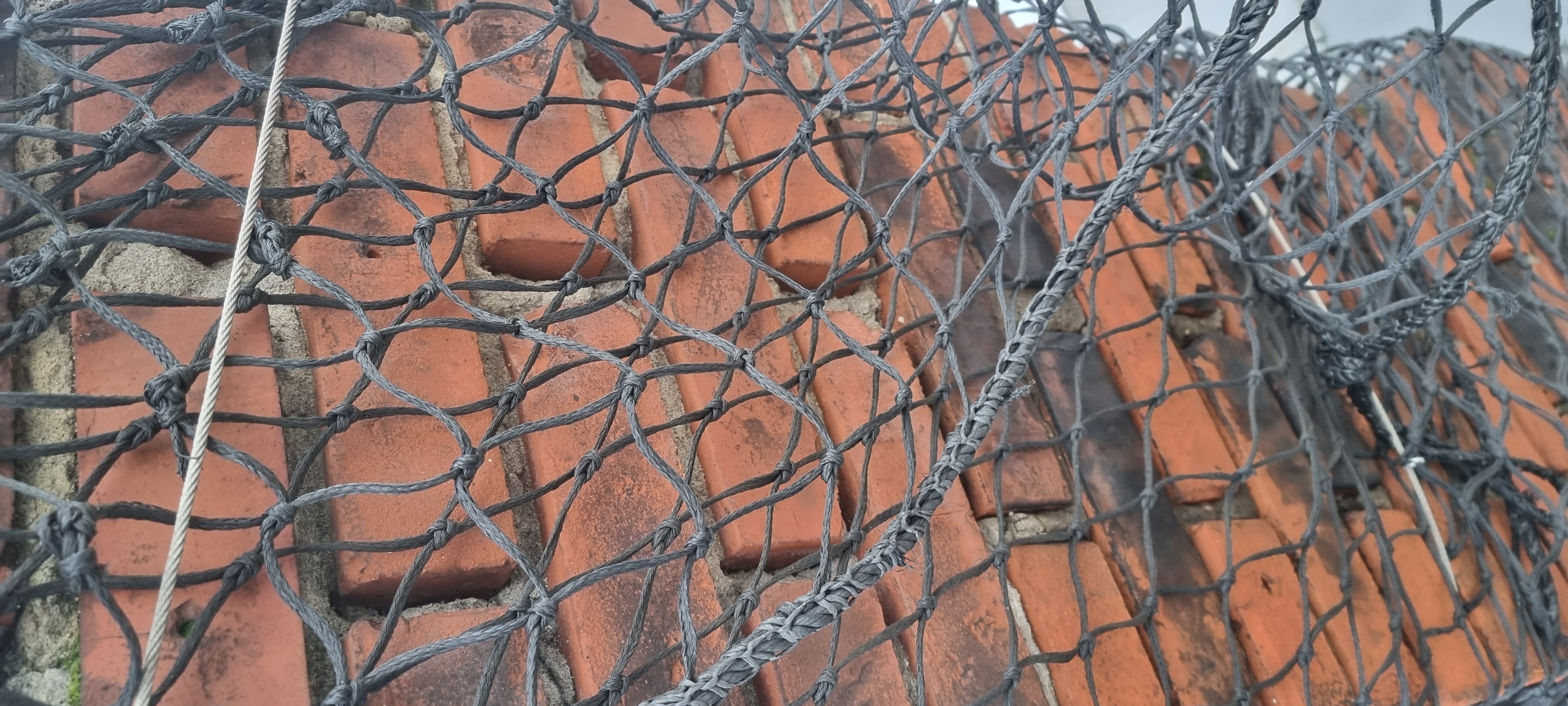Kritisk mursten presser igennem sikkerhedsnet, aktiv nedstyrtningsfare dokumenteret med drone