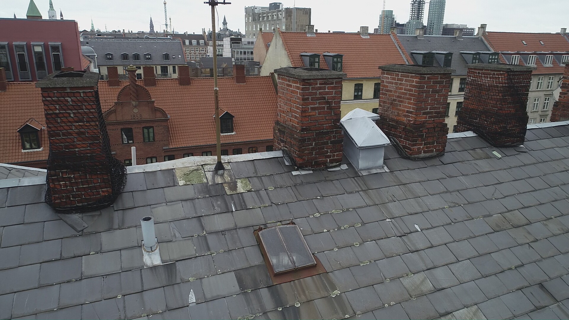 Dronefoto af kritisk skadet skorsten med sikkerhedsnet i Gentofte